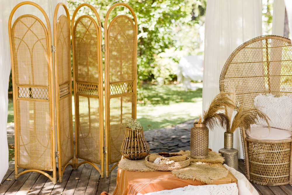 Terraza bohemia con mobiliario de ratán, elementos decorativos naturales y artesanales, ideal para crear un ambiente relajado y con encanto al aire libre.